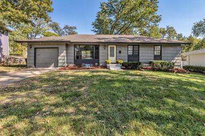 Ranch-style house featuring a front yard and a garage | Image 1