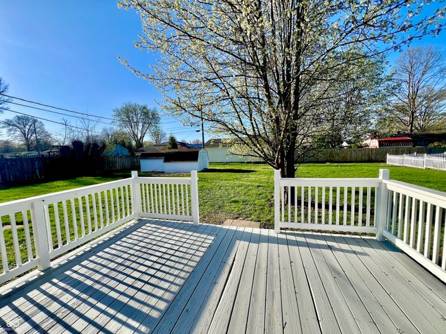 wooden deck with a yard, a fenced backyard, and an outdoor structure | Image 23