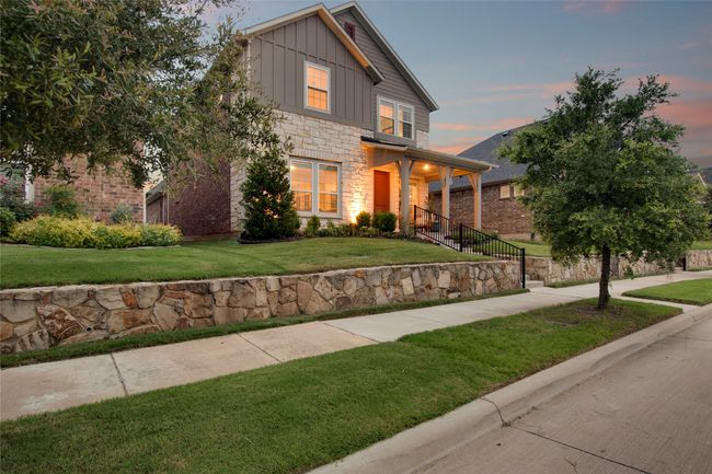View of front of house featuring board and batten siding, stone siding, and a front yard | Image 32