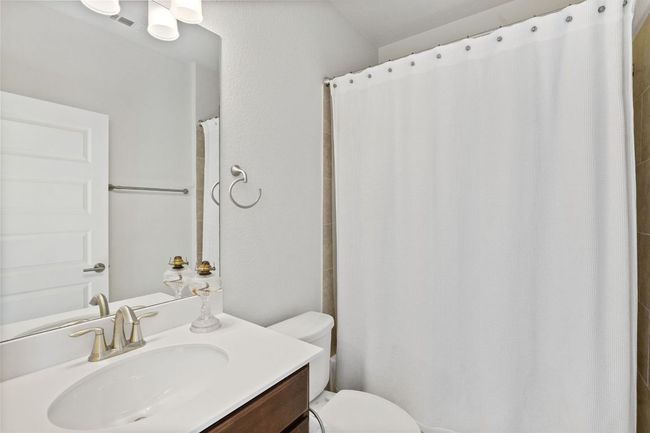 Full bath with toilet, vanity, and curtained shower | Image 14