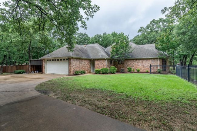 Ranch-style house featuring driveway, an attached garage, brick siding, and a shingled roof | Image 9