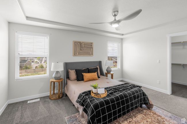 Bedroom featuring a raised ceiling, multiple windows, carpet, and visible vents | Image 19