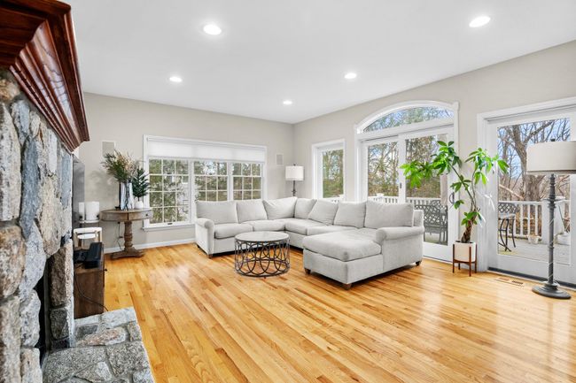 Sunlight pours into the spacious family room through oversized windows and glass doors that lead to the full-length deck. | Image 13