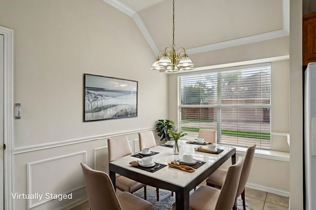 Virtually Staged Dining space featuring ornamental molding, lofted ceiling, light tile patterned floors, and a chandelier | Image 6