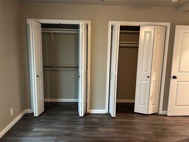 Unfurnished bedroom with multiple closets, baseboards, and dark wood-style floors | Image 30