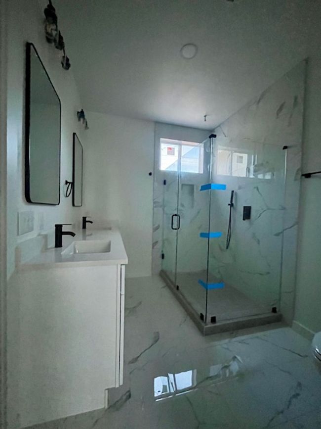 Bathroom with double vanity, a marble finish shower, marble finish floors, and walk in closet. | Image 6