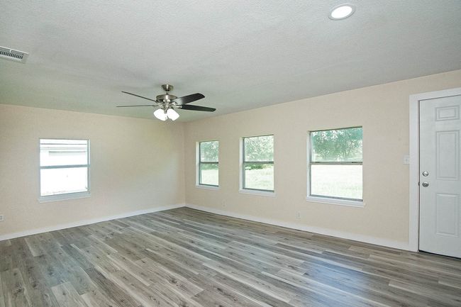 large Primary room featuring wood finished floors, a textured ceiling, and a ceiling fan | Image 15