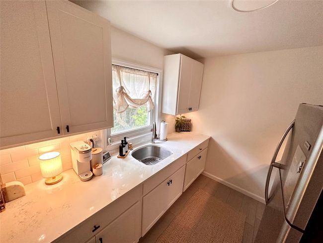 Kitchen featuring a sink, tasteful backsplash, light countertops, and baseboards | Image 9