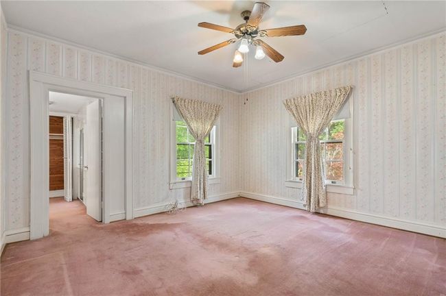 Carpeted primary bedroom with crown molding and a ceiling fan | Image 15