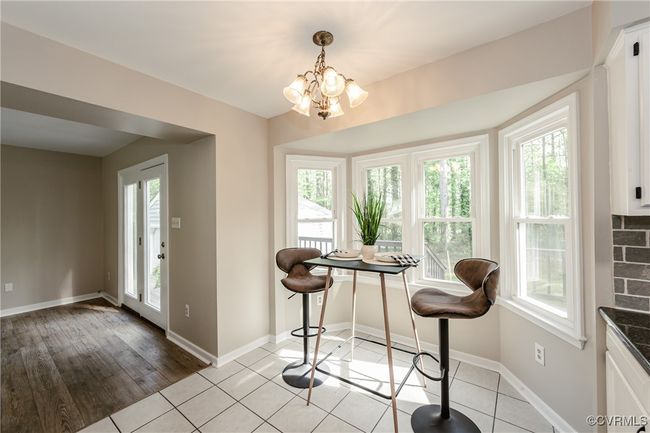 Dining area featuring plenty of natural light, baseboards, an inviting chandelier, and light tile patterned floors | Image 20
