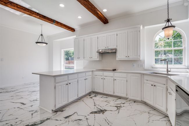Kitchen with a sink, dishwasher, beam ceiling, black electric stovetop, and white cabinetry | Image 11