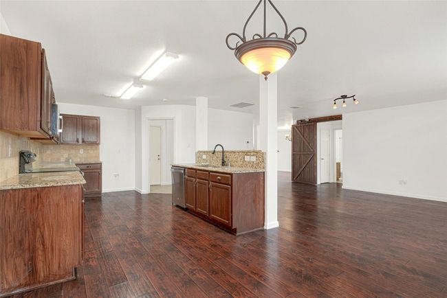 Kitchen featuring appliances with stainless steel finishes, tasteful backsplash, a sink, and open floor plan | Image 13