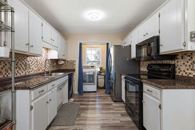 The kitchen boasts white cabinets that provide ample storage, paired with a stylish tile backsplash. 2803 Black Stallion Ct Murfreesboro, TN 37130 | Image 3