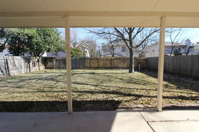 Fenced backyard with a patio | Image 24