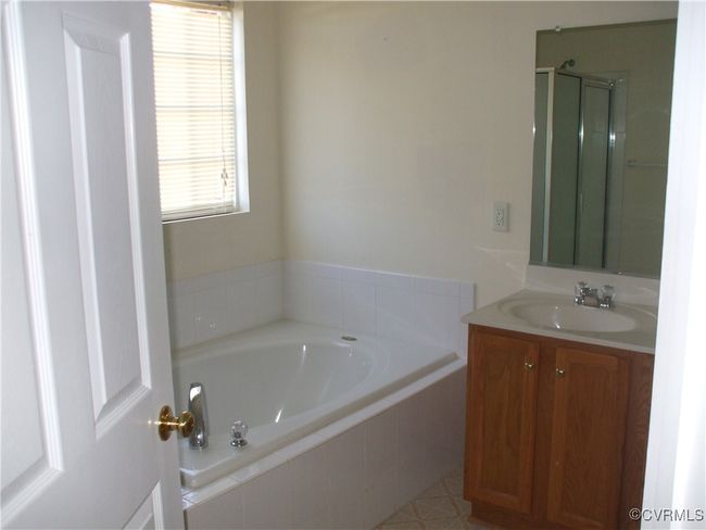 Bathroom featuring a garden tub, vanity, and a shower stall | Image 7