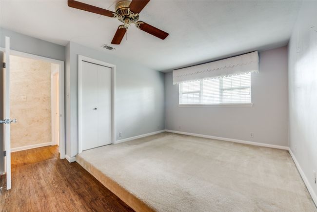 Unfurnished bedroom with a closet, baseboards, ceiling fan, and wood finished floors | Image 17