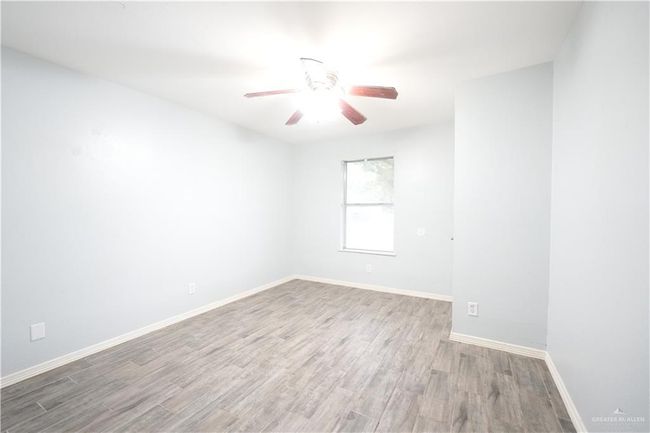 Unfurnished room with light wood-style floors and a ceiling fan | Image 14