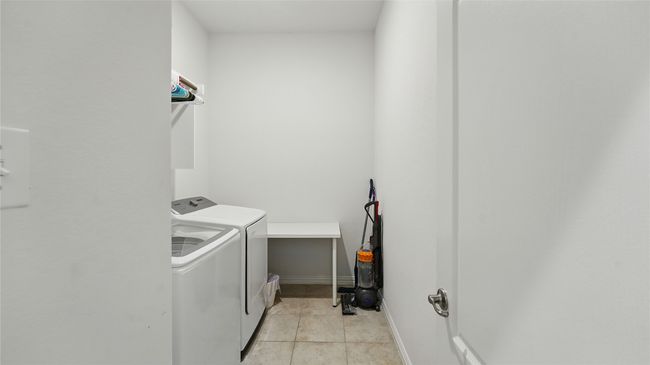 Laundry area featuring washing machine and clothes dryer and light tile patterned flooring | Image 30