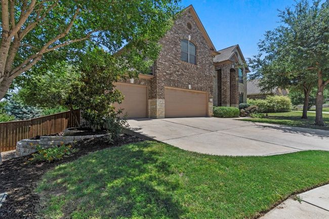 A stately brick exterior, manicured landscaping, and a spacious three-car garage create a striking first impression with undeniable curb appeal! | Image 5