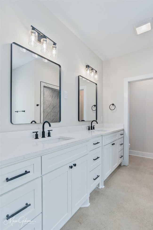 Bathroom with double vanity, toilet, and a sink | Image 10