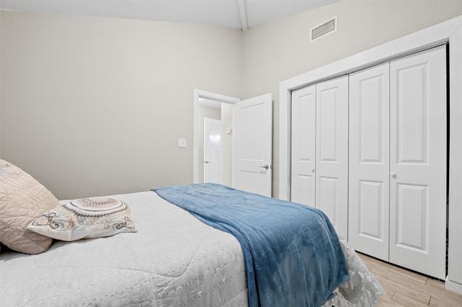 Bedroom with light wood-type flooring, a closet, and visible vents | Image 15