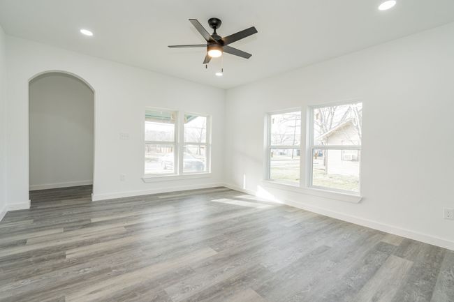 Spare room with arched walkways, ceiling fan, recessed lighting, wood finished floors, and baseboards | Image 6