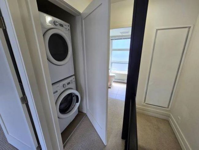 Laundry room with stacked washer and clothes dryer, carpet, and baseboards | Image 23