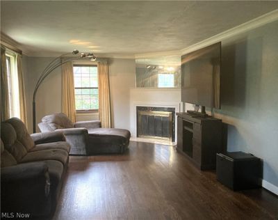 Living room with a premium fireplace, ornamental molding, and hardwood / wood-style floors | Image 2