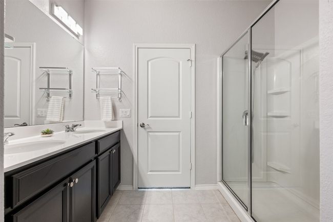 Full bath with double vanity, a shower stall, tile patterned flooring, and a sink | Image 20