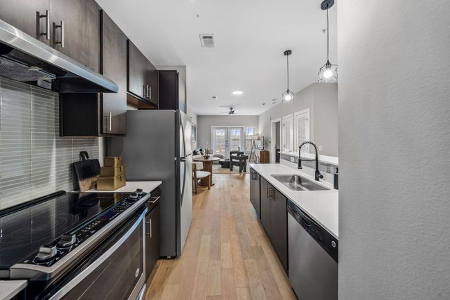 Kitchen with visible vents, range hood, stainless steel dishwasher, electric range, and a sink | Image 13