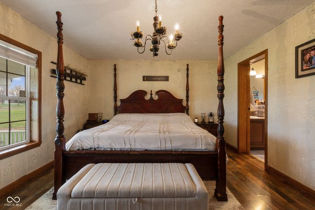 bedroom with a chandelier, hardwood / wood-style flooring, and a textured wall | Image 35