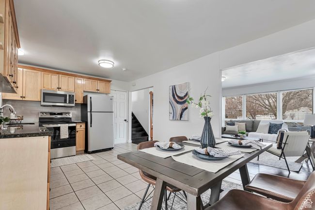 Dining room with light tile patterned floors and stairs | Image 10