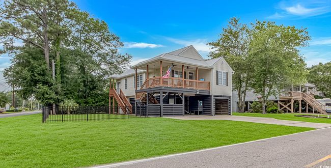 Beach home featuring stairs, ceiling fan, covered porch, and a carport | Image 34