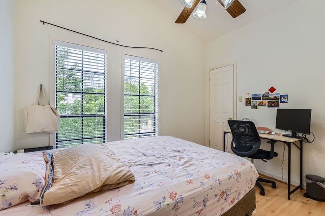 Bedroom featuring baseboards, wood finished floors, a ceiling fan, and lofted ceiling | Image 19