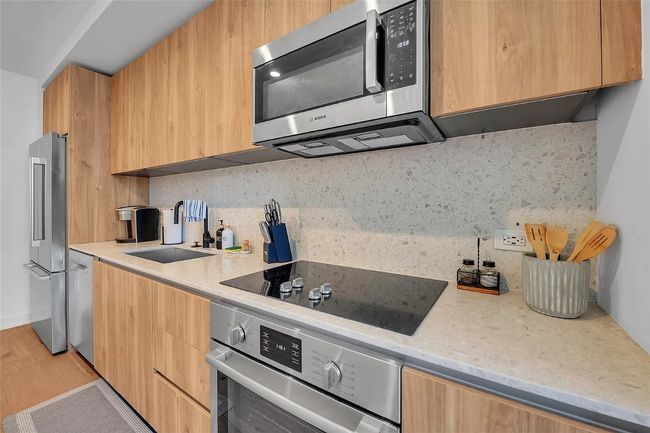 Kitchen with stainless steel appliances, modern cabinets, and tasteful backsplash | Image 8