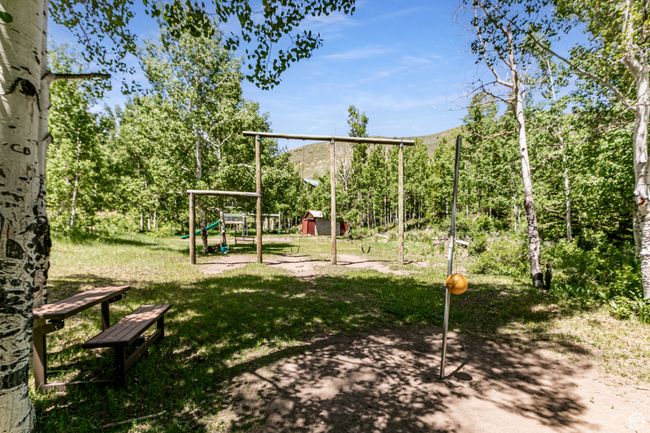 View of jungle gym featuring a shed, a yard, and a mountain view | Image 27
