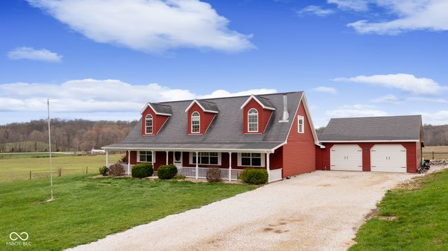 cape cod house with gravel driveway, a front yard, an outbuilding, fence, and covered porch | Image 50