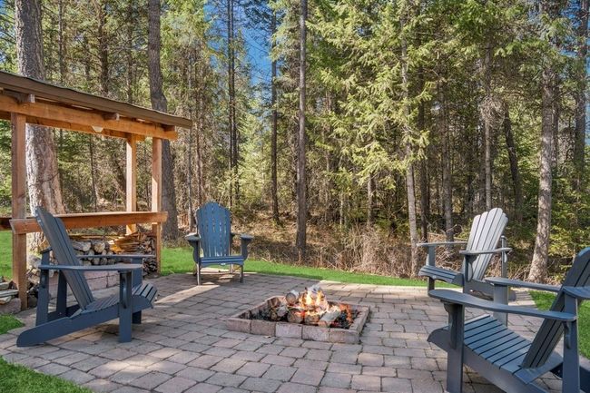 Fire pit with stone patio and a private wooded view. Located just off the main house. | Image 14