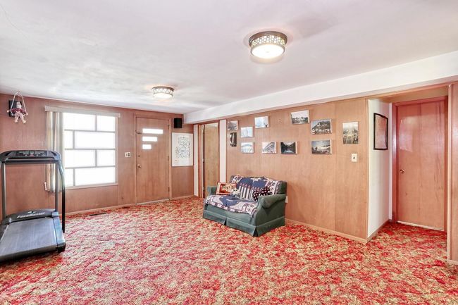 Sitting room featuring wooden walls, baseboards, and carpet floors | Image 26