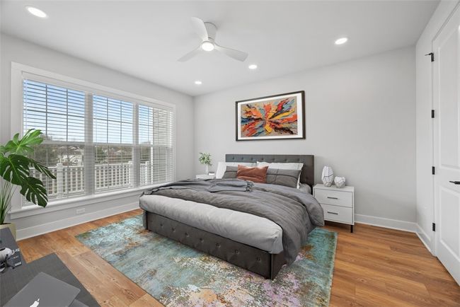 1st floor Primary bedroom has wall of windows with custom blinds. LVP flooring, recessed lighting, ceiling fan, walk-in closet | Image 20