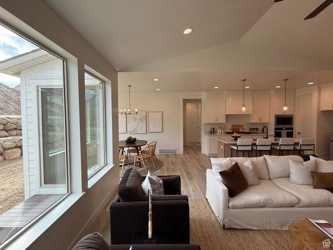Living room featuring recessed lighting, visible vents, vaulted ceiling, a chandelier, and light wood-type flooring | Image 6