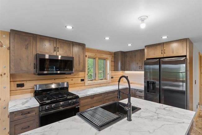 Kitchen featuring stainless steel appliances, light counters, and farmer's sink | Image 11