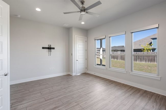 Empty room with light wood-type flooring, a ceiling fan, and recessed lighting | Image 18