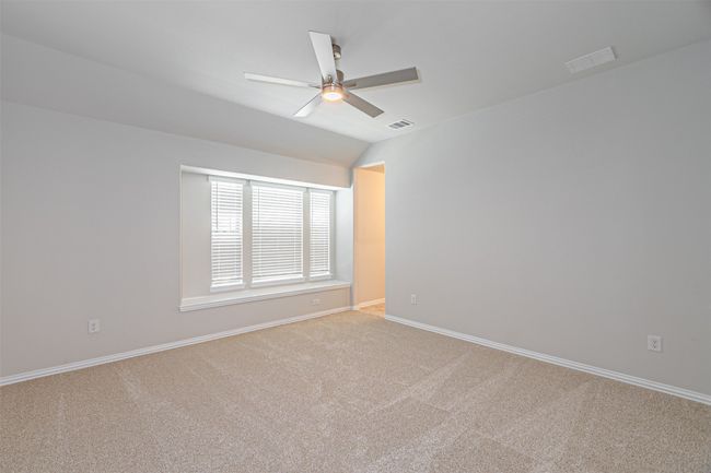 Spare room with ceiling fan, carpet floors, and vaulted ceiling | Image 37