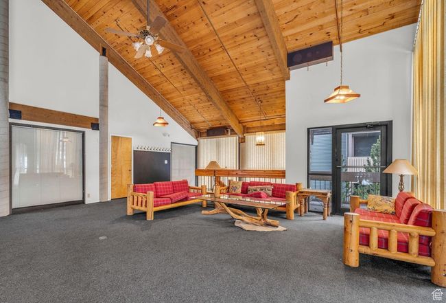 Living room featuring beamed ceiling, carpet flooring, ceiling fan, wooden ceiling, and high vaulted ceiling | Image 27