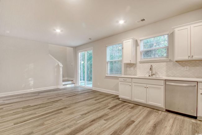 Kitchen featuring dishwasher, white cabinetry, and plenty of natural light | Image 14