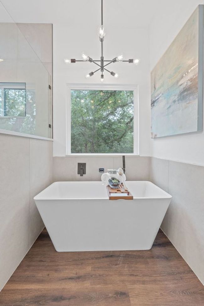 Full bath featuring a freestanding soaking tub, and a chandelier | Image 28