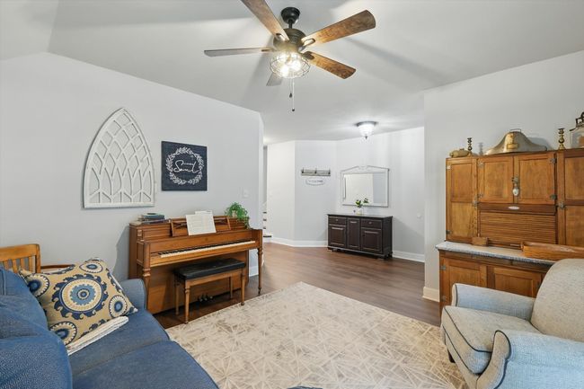 Living room with ceiling fan and dark wood-style floors | Image 8