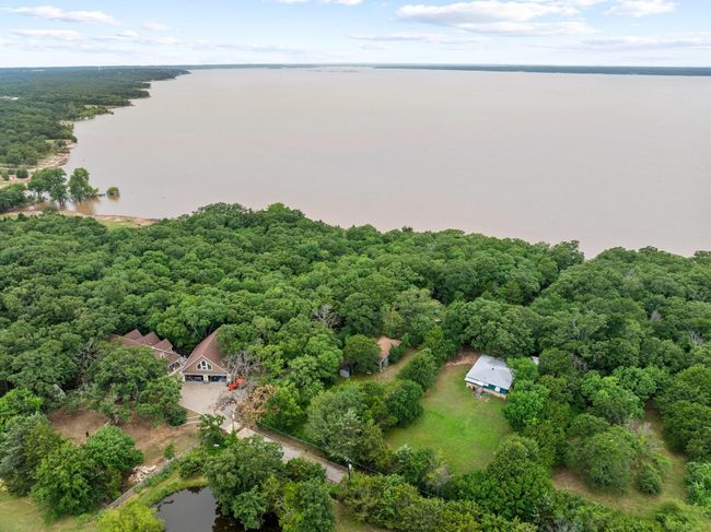 Aerial view of property's location with a large body of water and a heavily wooded area | Image 6