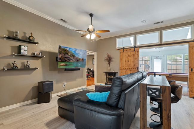 Living area featuring crown molding, wood finished floors, baseboards, and a ceiling fan | Image 10